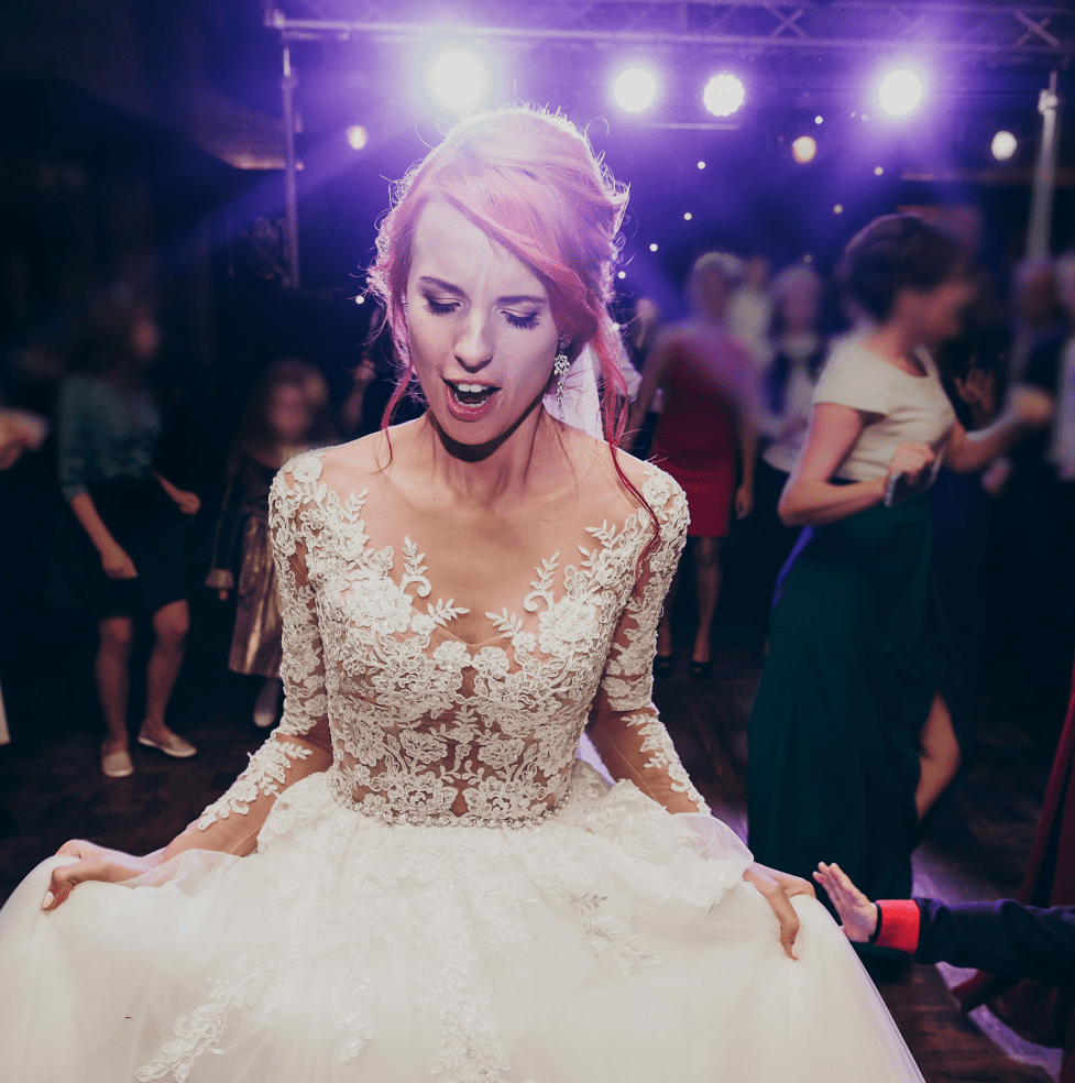 Novia/novio bailando durante la celebración de su boda. Focos iluminan el fondo.